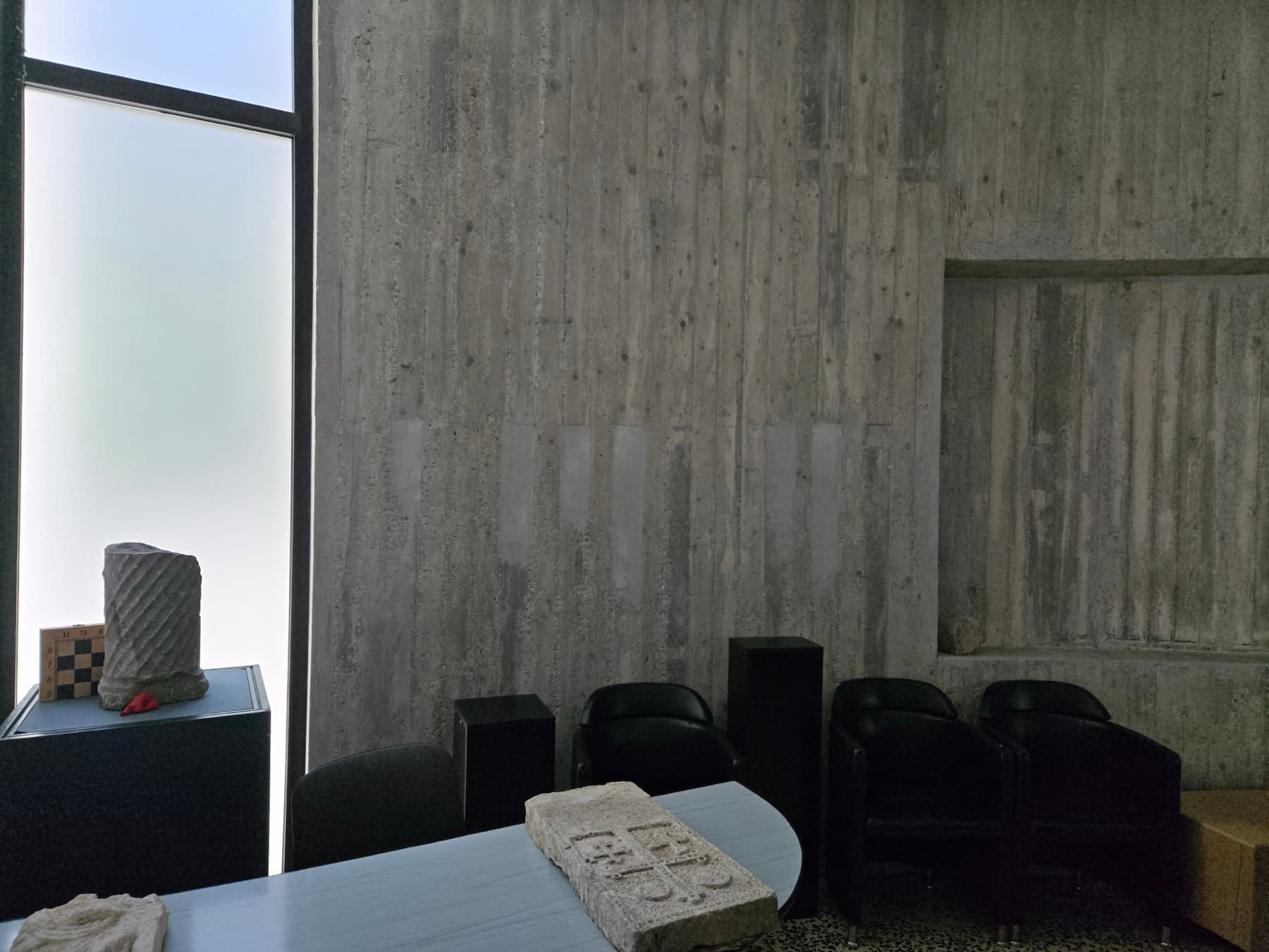 Museum interior with concrete walls and artefacts.