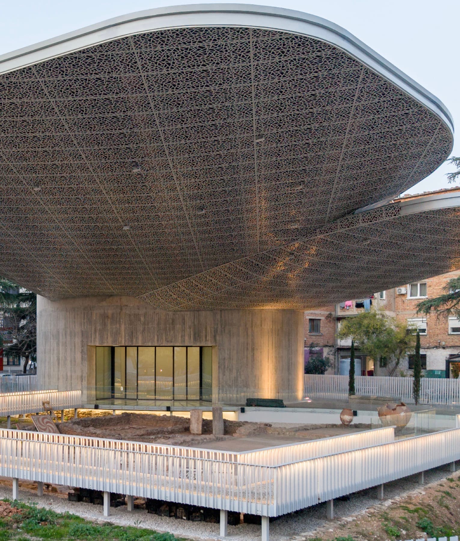 The award-winning modern pavilion of Mozaiku i Tiranës, its perforated canopy sheltering the Roman villa excavation, with the city beyond.