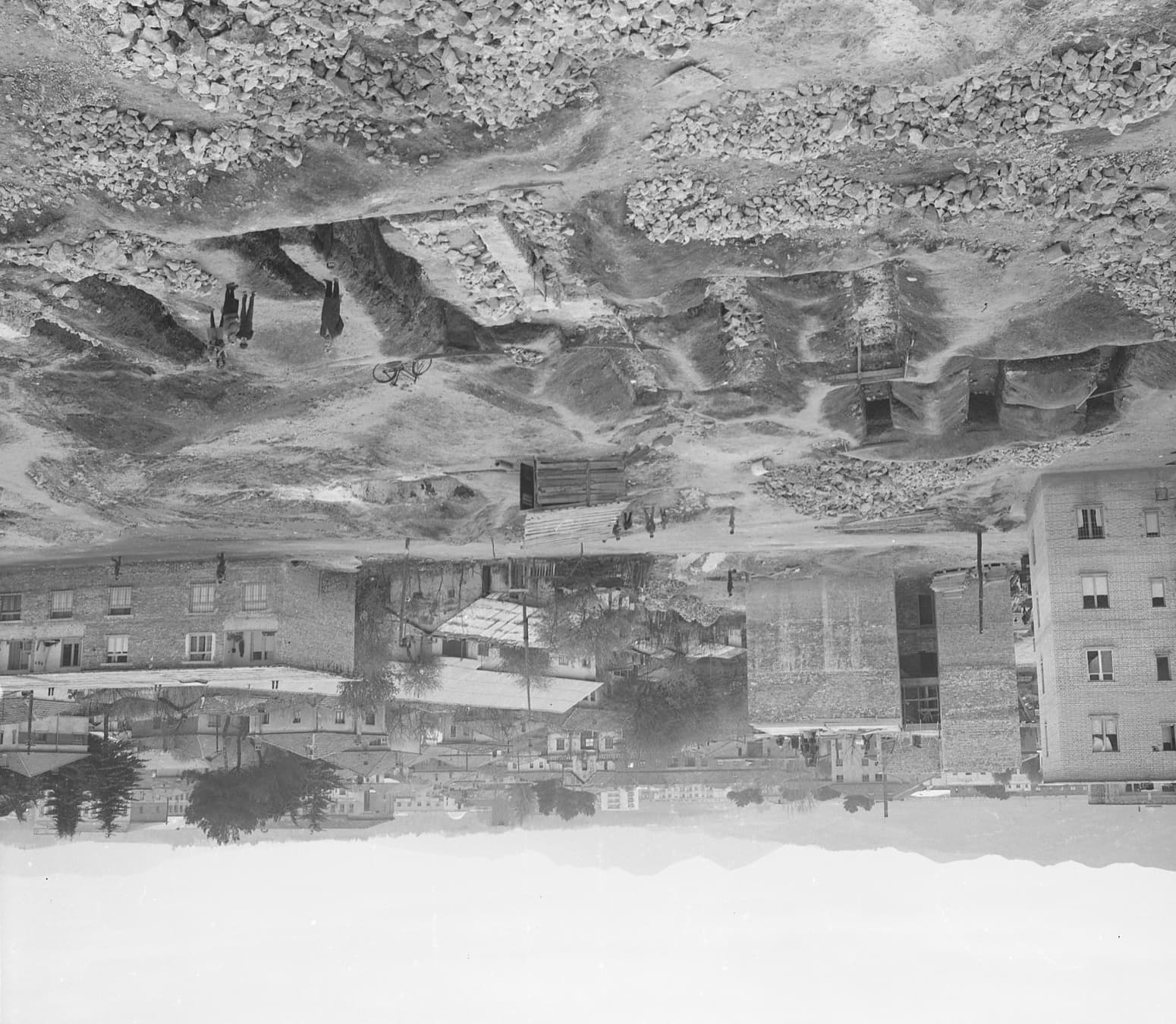 Black-and-white 1972 photograph of the excavation in the Partizani block of Tirana, with residential buildings behind the dig.